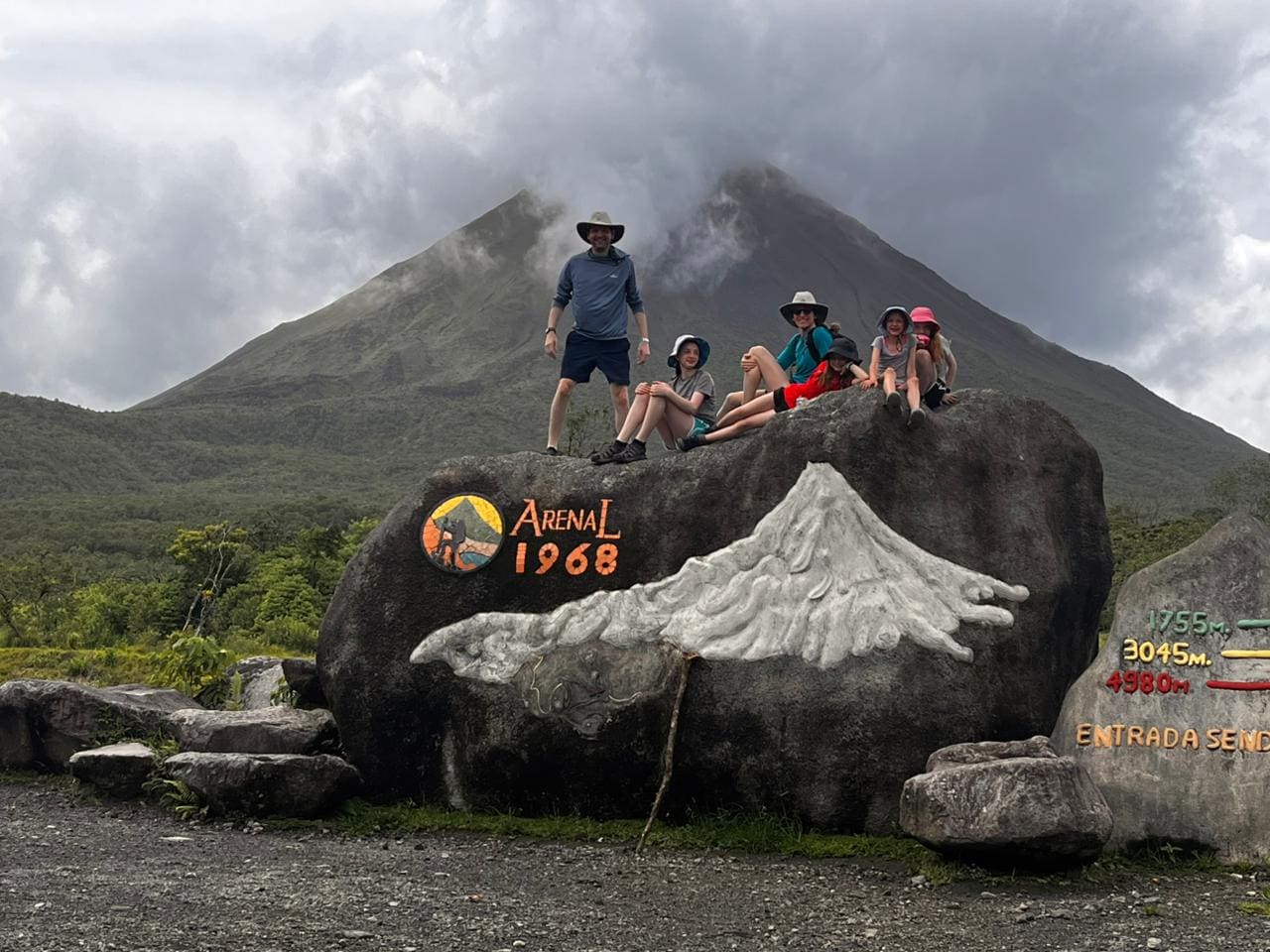 Family at the Arenal 1968 lava trail with the volcano behind